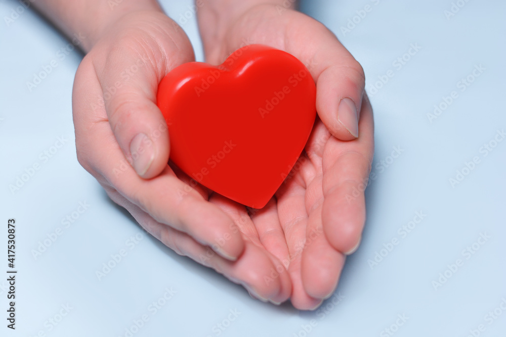 Red heart in man's hands isolated on blue background. Healthcare and hospital medical concept. Symbolic of Valentine day.Top view with space for text.