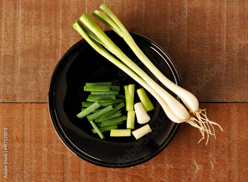 spring onions on a black plate,warm color
