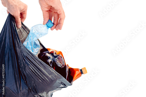 Plastic Pollution, Plastic waste problem, synthetic plastic products in the environment. Mans hand putting plastic bottles in trash bag
