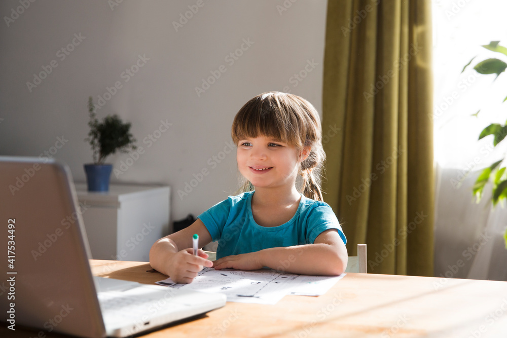 schoolgirl is using a laptop and study online with video call teacher at home. home schooling, distant learning schoolgirl is using a laptop and study online with video call teacher at home. home schooling, distant learning