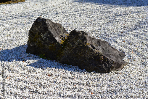 Huge isolated rock surrounded by white ground stones photo