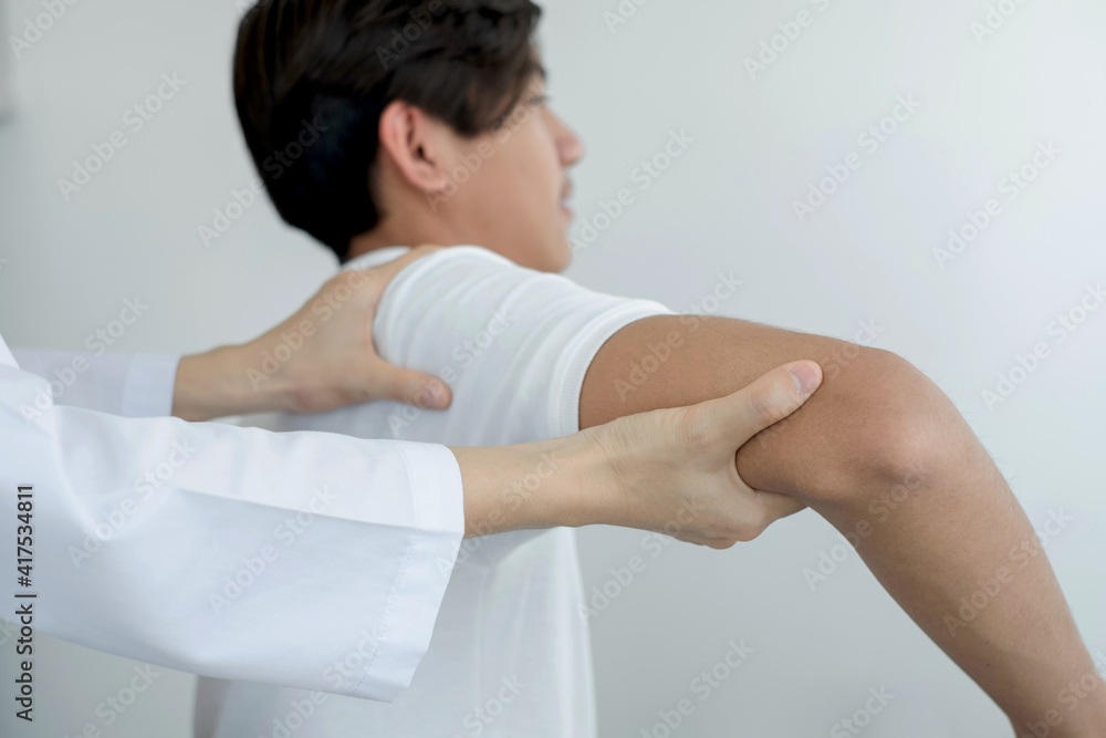 Fototapeta premium Female physiotherapists provide physical assistance to male patients with shoulder injuries massage their shoulders for muscle recovery in the rehabilitation center. Physiotherapy concepts