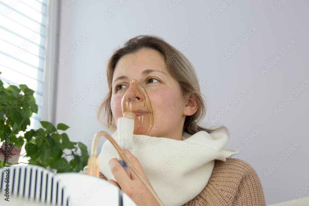 portrait of a young woman inhaling medicines for bronchitis and asthma at home portrait of a young woman inhaling medicines for bronchitis and asthma at home
