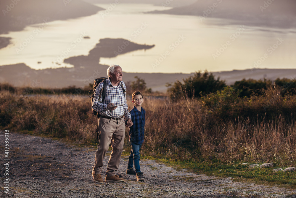 Grandfather and grandson hiking, using digital tablet. Grandfather and grandson hiking, using digital tablet.