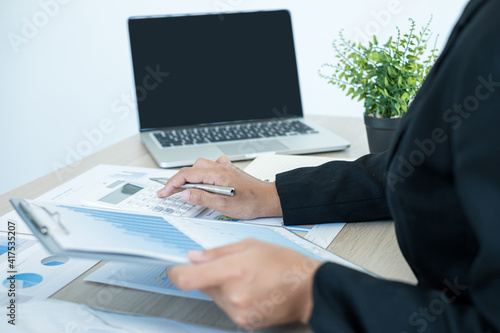 The businesswoman hand sits at their desks and calculates financial graphs showing the results of their investments planning the process of successful business growth