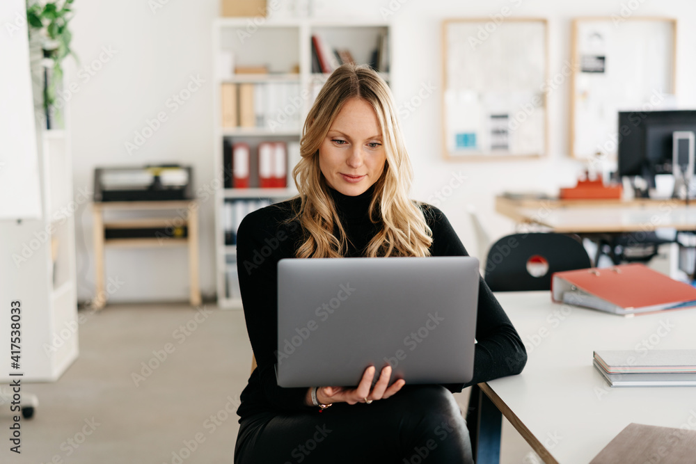 Young woman with laptop in a modern office Young woman with laptop in a modern office