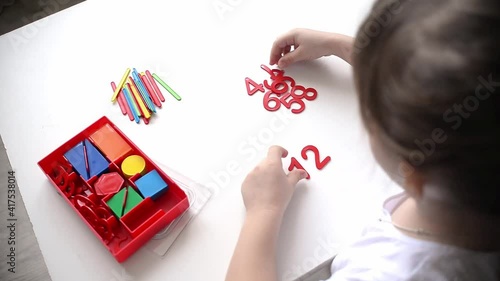 The child learns Number line and geometric shapes. The preschooler works with Montessori material. Educational logic toys for kid's. Children's hands close-up. Montessori Games for Child Development