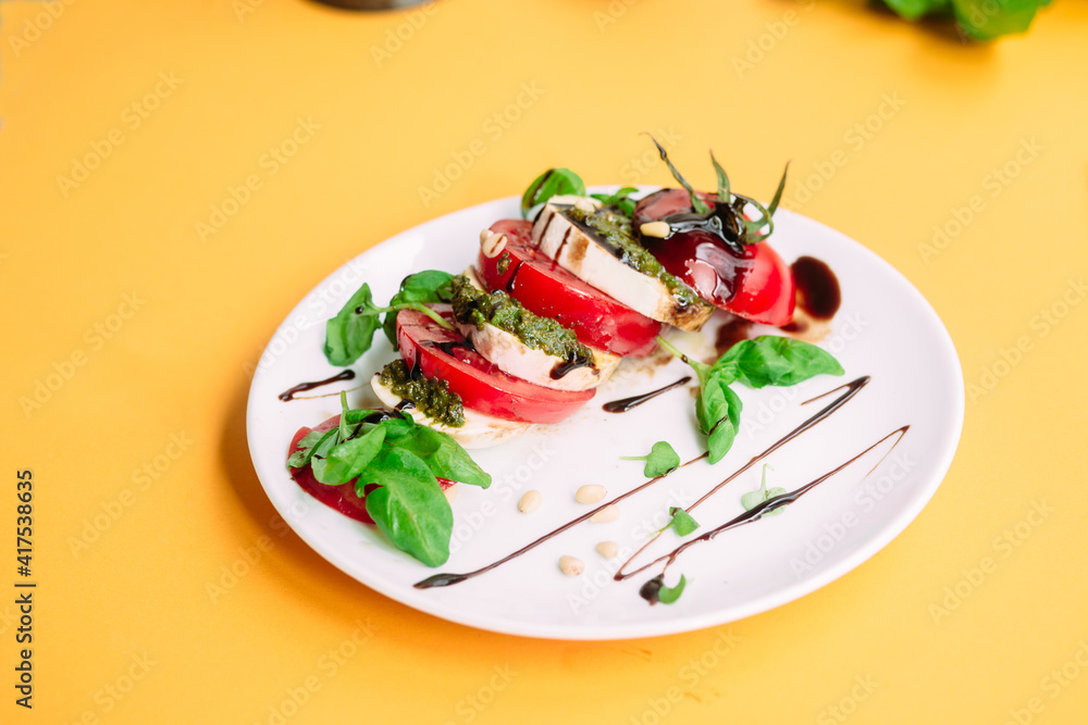 Caprese salad. Tomatoes, mozzarella, basil, pesto, balsamic sauce Caprese salad. Tomatoes, mozzarella, basil, pesto, balsamic sauce
