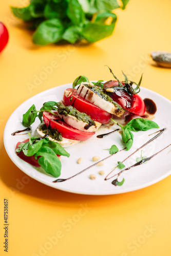 Caprese salad. Tomatoes, mozzarella, basil, pesto, balsamic sauce