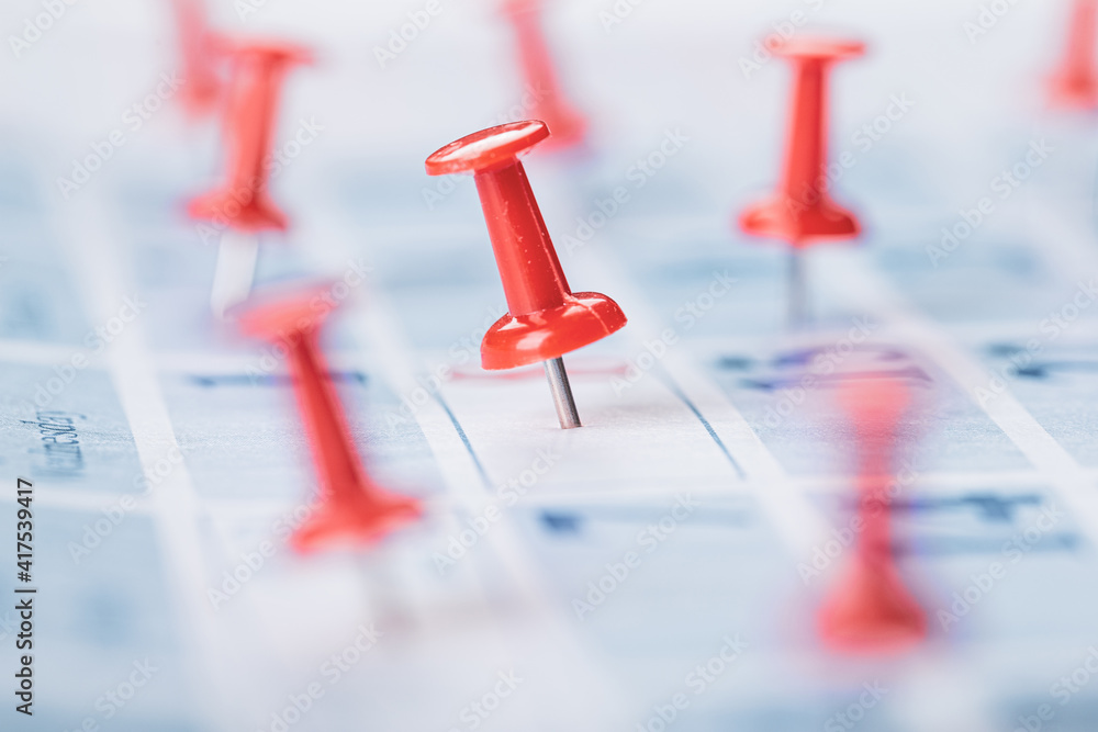 Fototapeta premium Calendar page for 2021, Concept image of a calendar with red push pins.