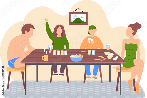 People playing in living room together. Happy family playing board game. Girl in lingerie looks at her husband. Son lays out cards. Parents in swimwear spend time with their children eat and drink