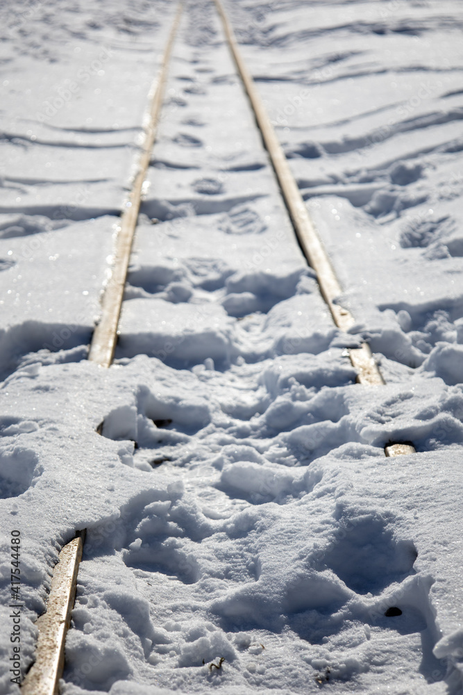 Schienen im Schnee mit Fussspuren Stock Photo | Adobe Stock