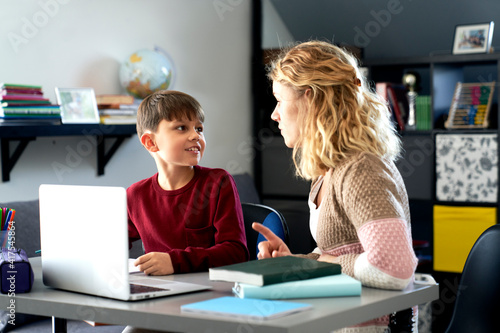 Boy gladly doing his homework with his mother