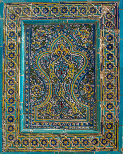 Intricate floral and geometric traditional blue turquoise and yellow tile decoration on facade of medieval mausoleum at Shah-i-Zinda necropolis in UNESCO listed Samarkand, Uzbekistan