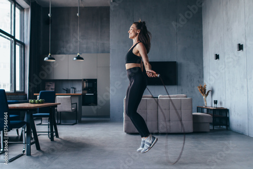 Sportsgirl with skipping rope at home. photo