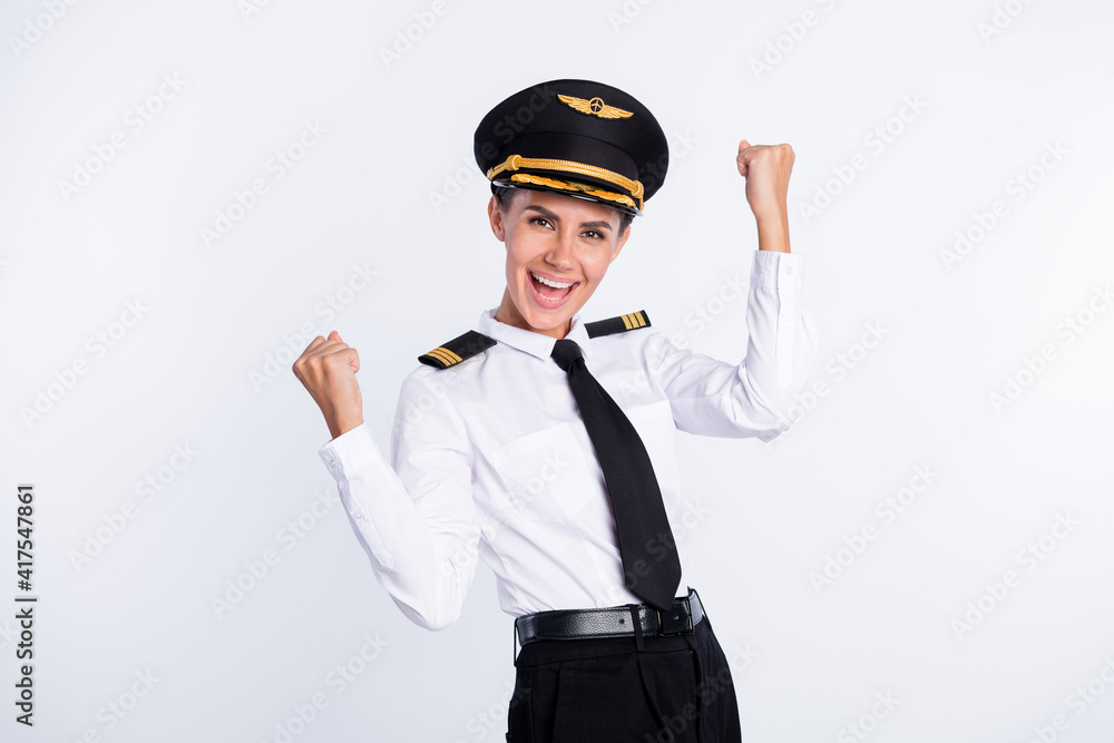Photo of cheerful girl raise fists open mouth wear aviator headwear uniform isolated white color background