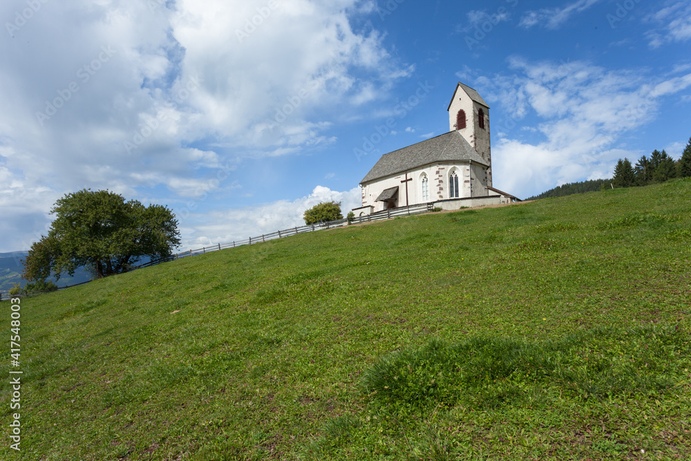St. Giacomo little church among a wide green meadow in St. Giacomo town , Val di Funes St. Giacomo little church among a wide green meadow in St. Giacomo town , Val di Funes