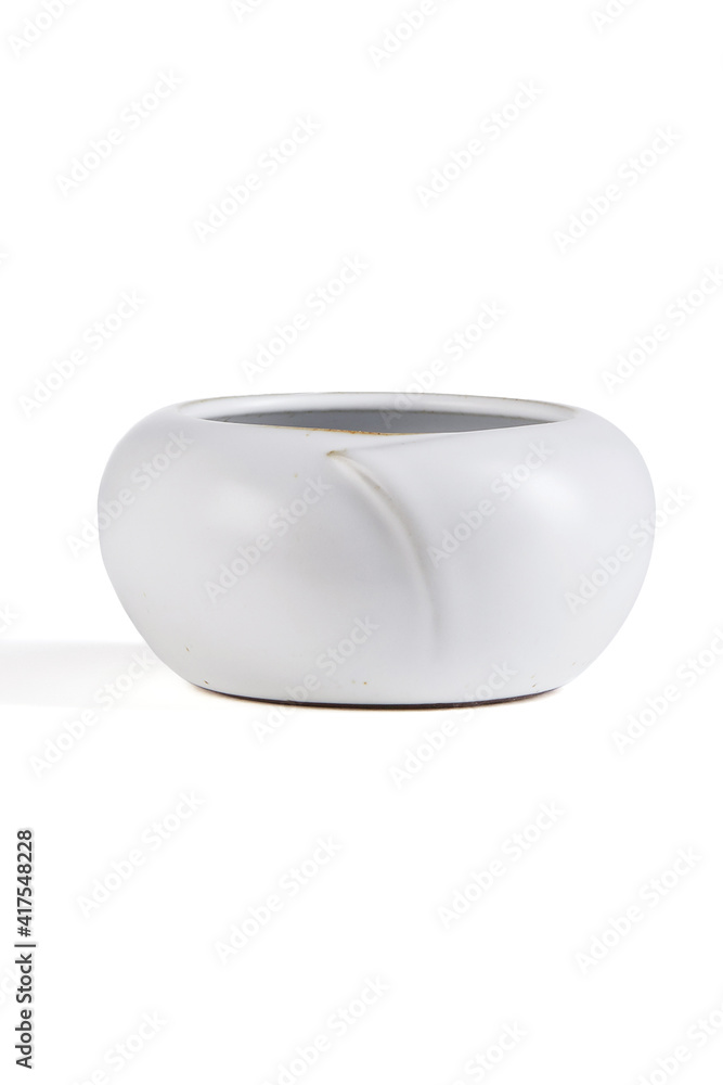 Subject shot of white ceramic vase with glazed surface. The low Scandinavian bowl is isolated on the white background. Subject shot of white ceramic vase with glazed surface. The low Scandinavian bowl is isolated on the white background.