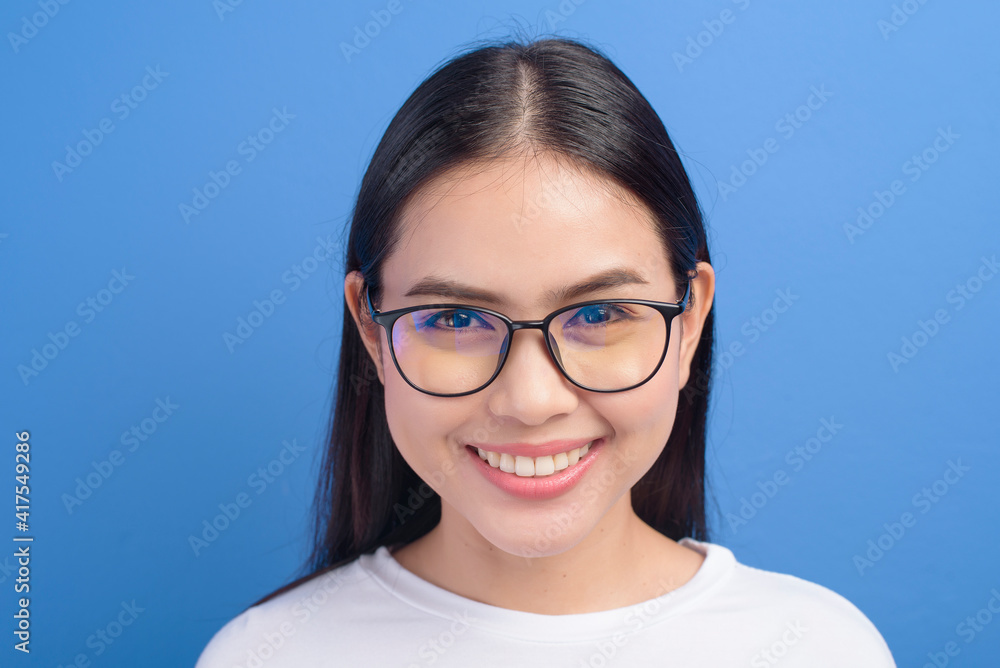 Portrait of young female wearing glasses over blue background studio, healthcare concept Portrait of young female wearing glasses over blue background studio, healthcare concept