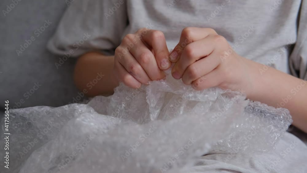Close up and cut view of child hands playing with bubble wrap. Close up and cut view of child hands playing with bubble wrap.