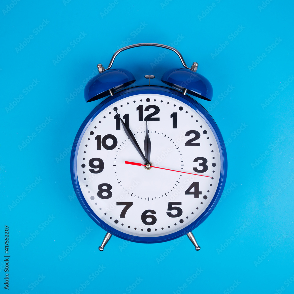 Classic alarm clock on light blue background Classic alarm clock on light blue background