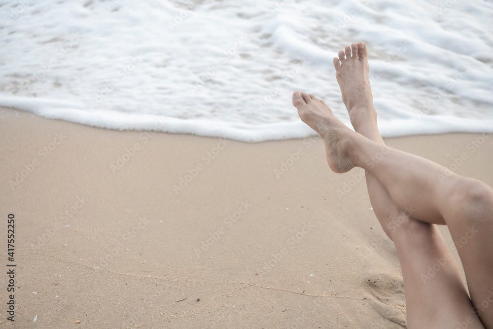 Traveller with bare foot and legs relaxing on beach Traveller with bare foot and legs relaxing on beach