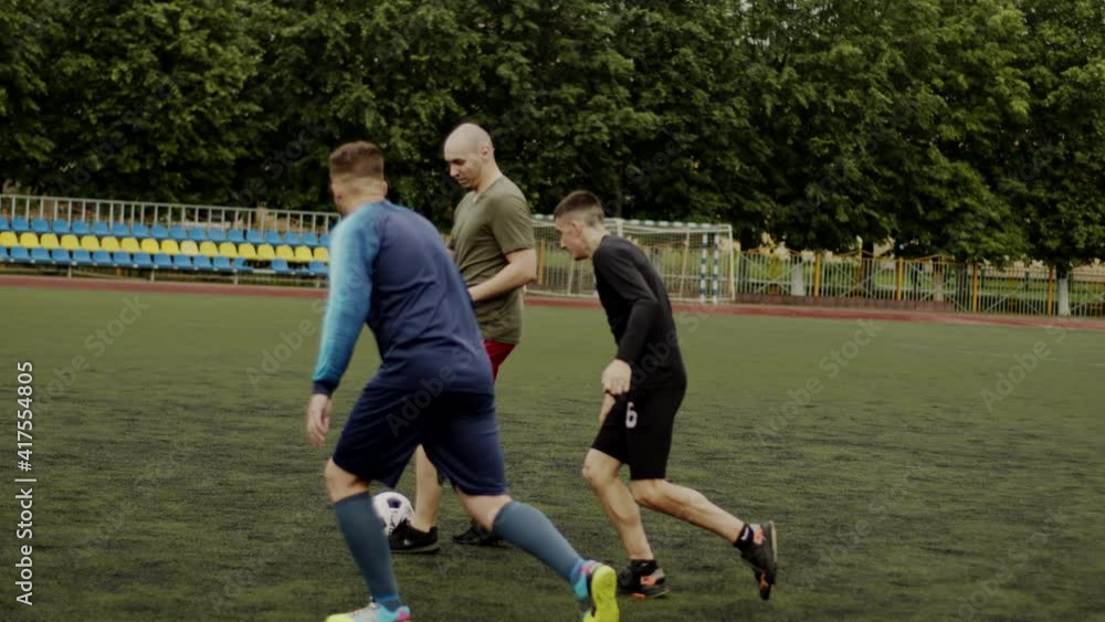 Friends play soccer and give a pass to each other. Football amateur game in a small stadium. Workout training. Team friendly match. Sport Friends play soccer and give a pass to each other. Football amateur game in a small stadium. Workout training. Team friendly match. Sport