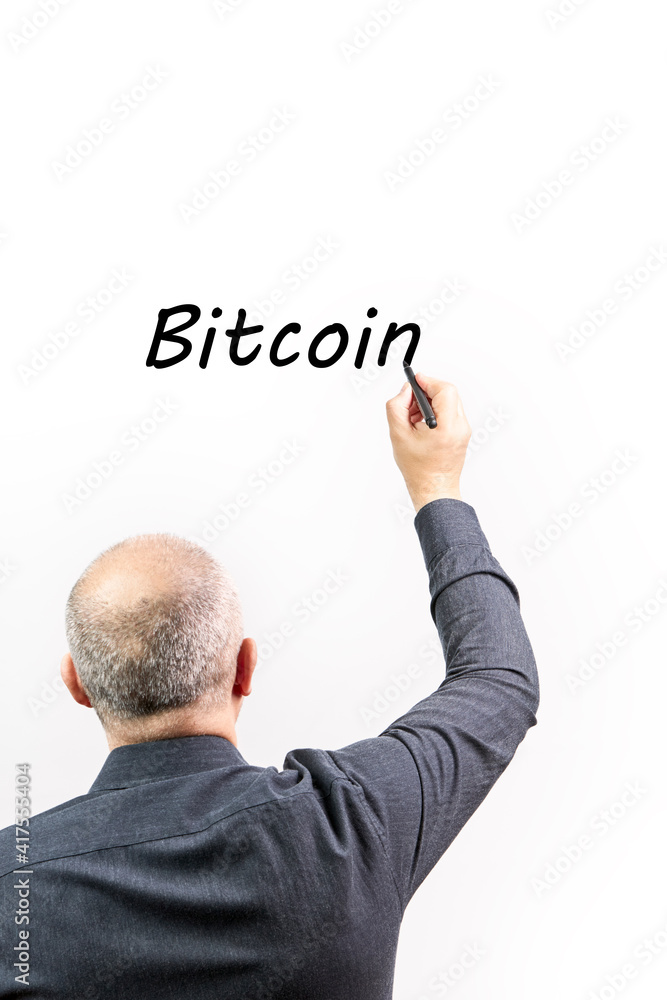 Executive man writing the word Bitcoin with a black marker pen Executive man writing the word Bitcoin with a black marker pen