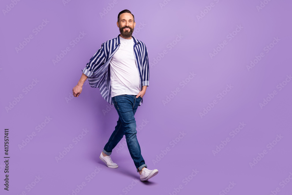 Full body photo of mature man with hands in denim pockets go empty space isolated over violet color background Full body photo of mature man with hands in denim pockets go empty space isolated over violet color background
