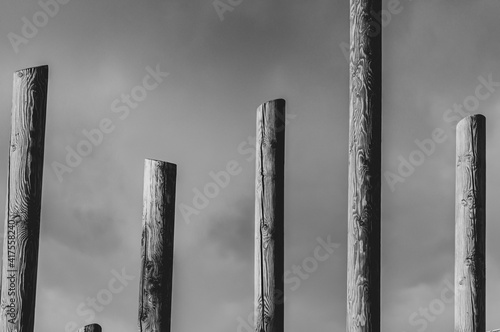 Abstract black and white pillars against cloudy sky