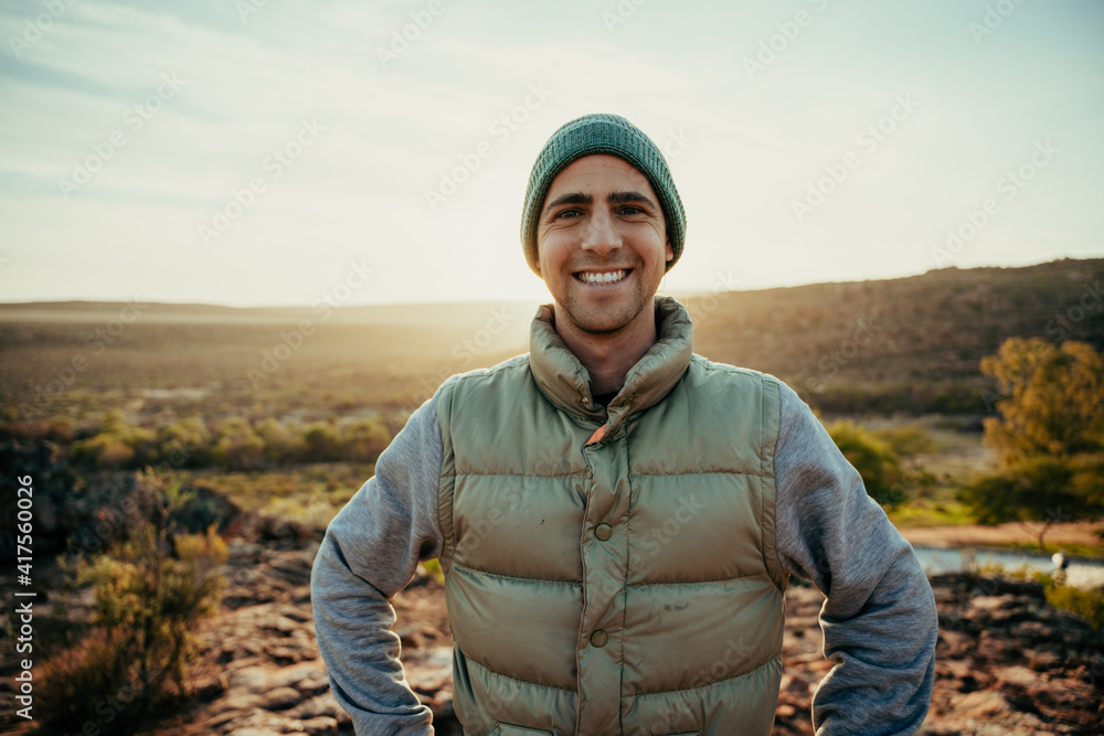 Caucasian male free spirit smiling while enjoying sunset walking in wilderness