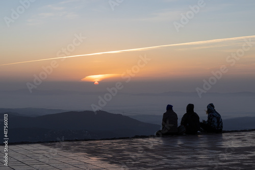 Tourists watching an Amazing sunrise from the top of La Mola Mountain in the Parc natural de Sant Llorenc del Munt i l'Obac, Valles Occidental, Catalonia, Spain. Copy space.