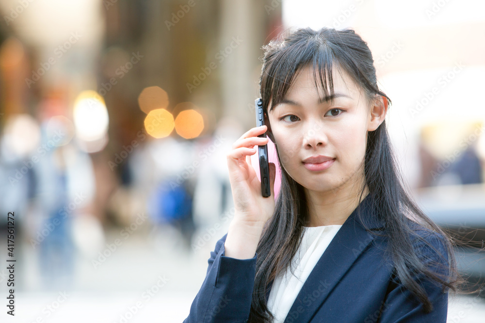 屋外で携帯電話で通話する女性 屋外で携帯電話で通話する女性