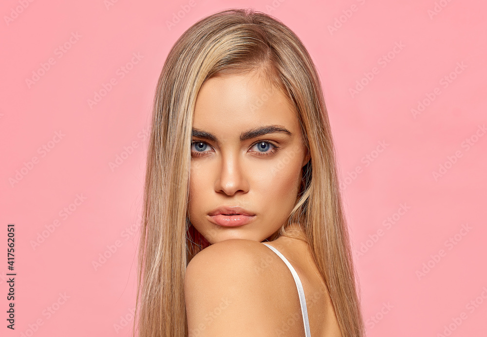 Naklejka premium Portrait of sexy blonde woman on pink background