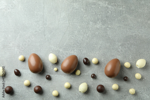 Easter chocolate eggs and candies on gray background