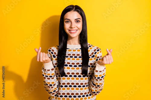 Photo of young attractive girl happy positive smile show money cash sign isolated over yellow color background