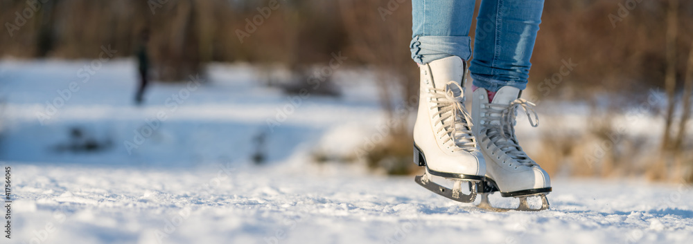 Cutout of female legs in ice-skates while ice-skating on a lake Cutout of female legs in ice-skates while ice-skating on a lake