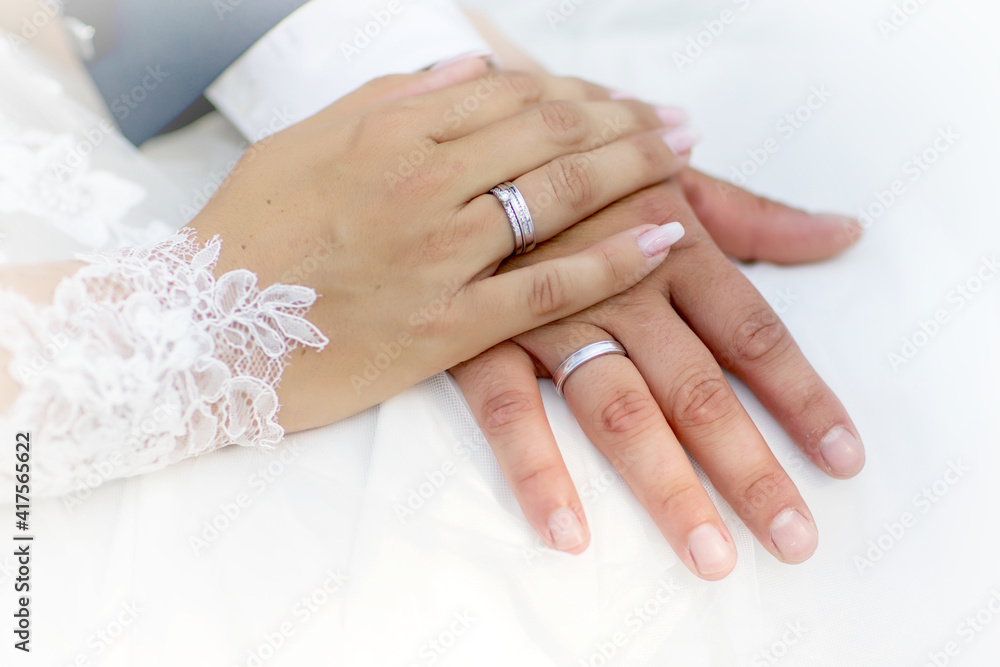 closeup of hands of bride and groom with wedding rings