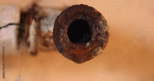 Water leaking from corroded pipe closeup footage