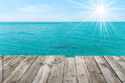 Blue sea with sun  water summer background  view from wooden table