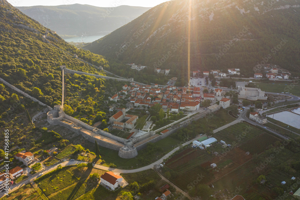 Aerial drone shot of Ston city wall over hill in Ragusa region near Dubrovnik in Croatia summer sunrise