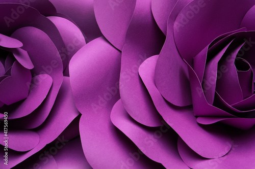 Beautiful purple flowers made of paper as background, top view