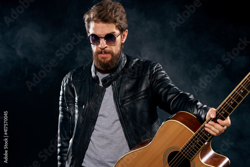 Male musician in leather jacket performed by musical group guitar