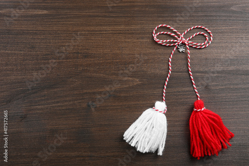 Traditional martisor on wooden background, top view with space for text. Beginning of spring celebration photo