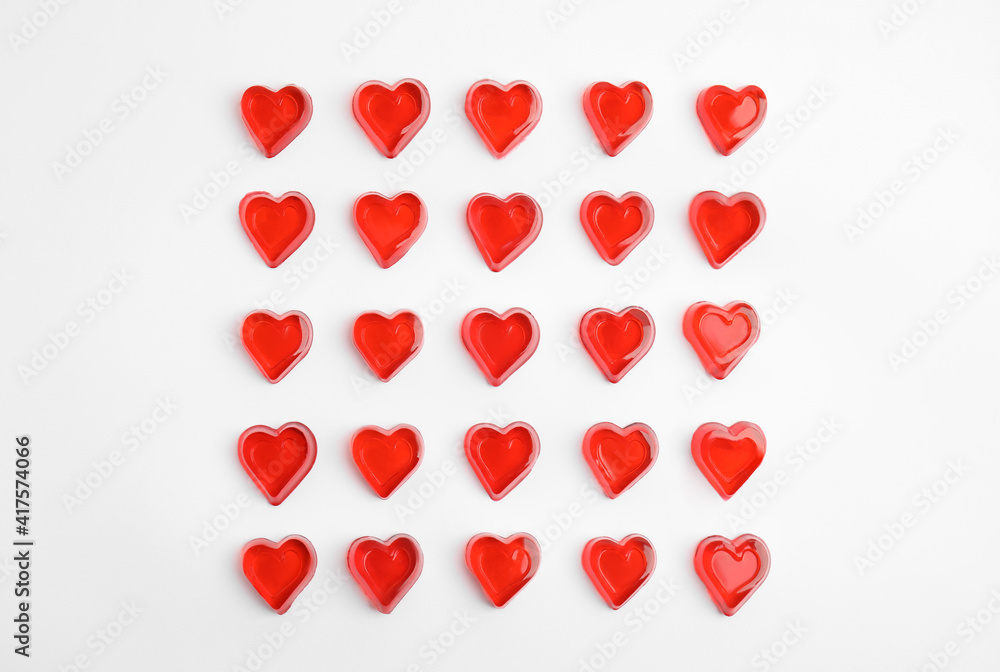 Sweet heart shaped jelly candies on white background, flat lay Sweet heart shaped jelly candies on white background, flat lay