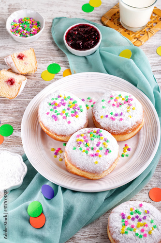 Carnival sprinkled doughnuts and confetti, holiday celebration, baking, top view
