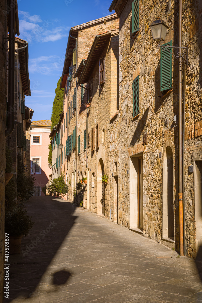 Narrow street with medieval houses, San Quirico d'Orcia, Italy