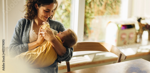 Loving mother feeding baby son with bottle photo