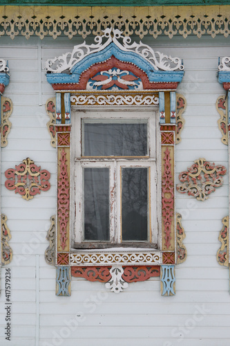 Ornamental window with carved frame on vintage wooden rural house in Nerekhta town, Kostroma region, Russia. Building facade. Russian traditional national folk style in architecture. Russan landmark photo