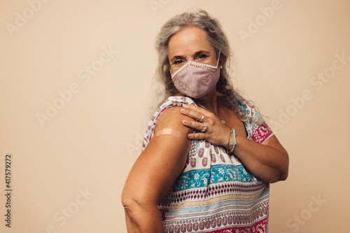 Fototapeta Woman showing her arm after getting vaccine